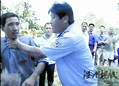 一村民欲阻止拆遷，被一個身穿監(jiān)察大隊制服的工作人員掐住脖子，野蠻推開