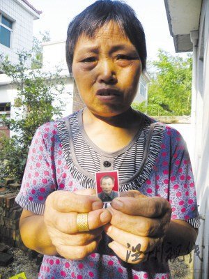 鮑祥義的妻子展示丈夫遺照。
