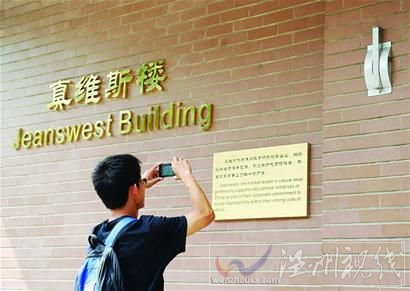 一名清華大學學生在拍攝“真維斯樓”的銘牌5月24日攝。