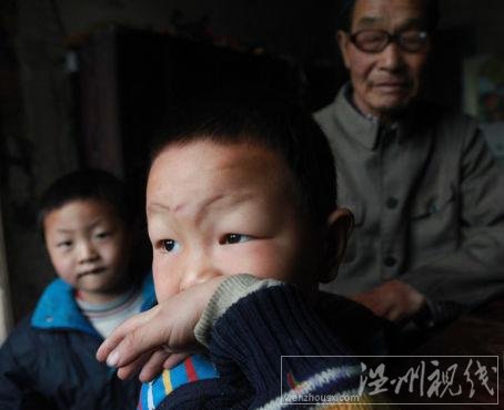 毛坪村的小男孩袁石(中)，告訴記者，他的妹妹袁麗一歲的時(shí)候，被搶走了，至今下落不明。他想念妹妹，多次夢(mèng)到她回家了。 記者 李漠 攝
