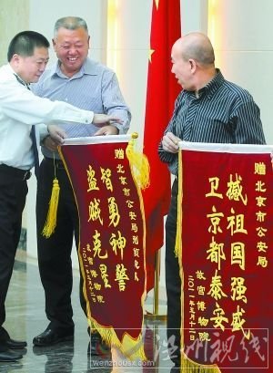 5月13日，故宮博物院負責人來到北京市公安局，向快速偵破故宮失竊案的市局有關(guān)部門贈送錦旗。錦旗中的“撼”字應為“捍”。本報記者 賈同軍攝 