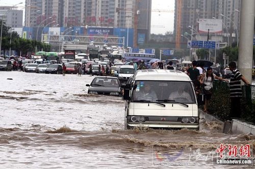 6月18日，車輛在武漢積水的道路上艱難行駛。當日，武漢降大到暴雨，全城多處交通要道積水嚴重，交通幾近癱瘓。中新社發 張暢 攝