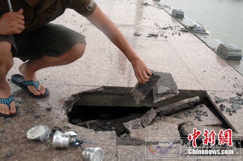 圖為橋欄垮塌時(shí)砸壞了人行道地面，損壞了燈光設(shè)施。