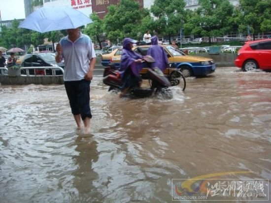 電動(dòng)車和行人匆匆穿過芙蓉路的引橋，仍然還是要卷起褲腿。　　陳劍岷 攝 圖片來源：星辰在線