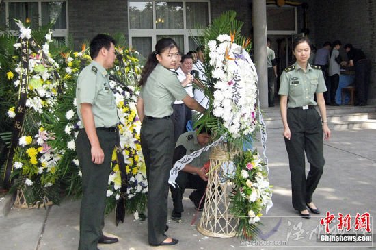 圖為薛明老人家門前送花圈的人們絡繹不絕。淮黎霞攝影報道