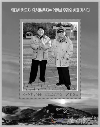 30日，朝鮮發(fā)行紀念金正日的郵票小型張2枚。其中一枚郵票的中央是金正日與金正恩在一起的照片，上端寫著“偉大領導者金正日同志永遠和我們在一起”。 新華社發(fā)