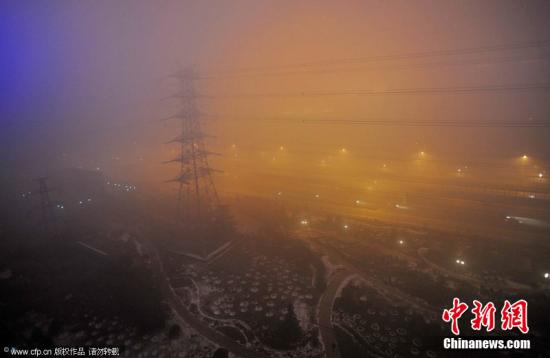 剛告別初雪，京城陷入“霧區”。2011年12月4日晚，北京阜石路石景山區楊莊段，被大霧籠罩。李文明 攝 CFP視覺中國