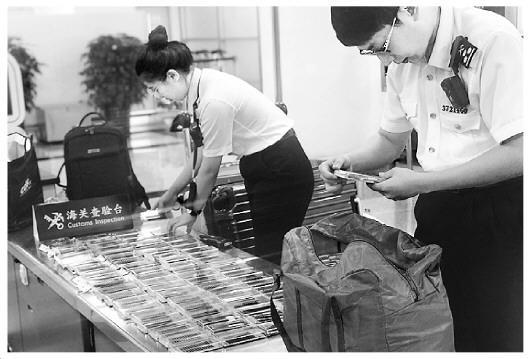 圖為海關(guān)工作人員在檢查旅客攜帶的假睫毛。王詠潔 攝 