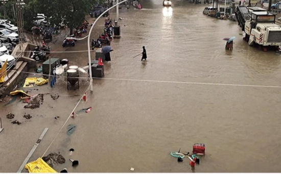 鄭州暴雨過后，人們沿著街道趟過洪水。